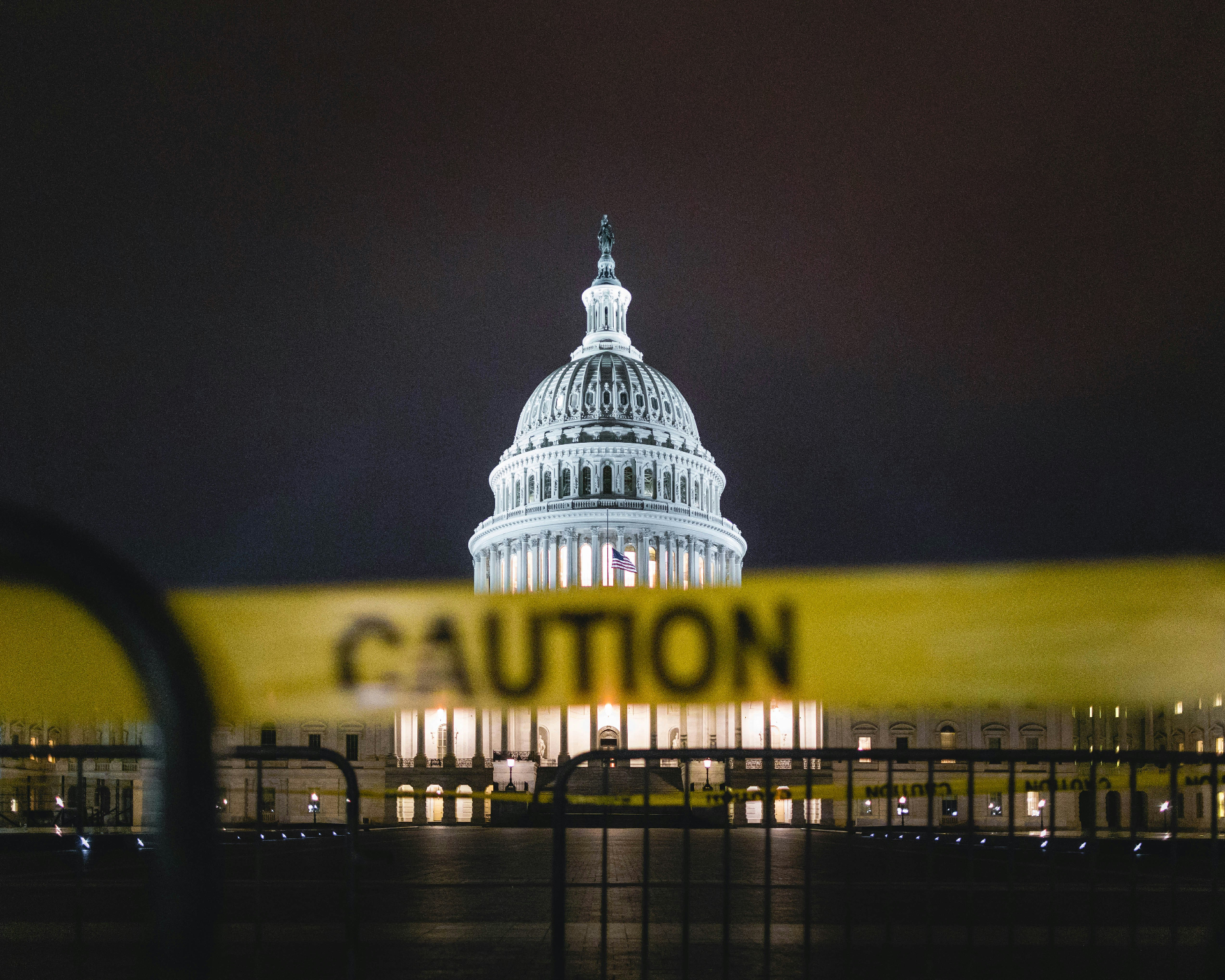 U.S. Capitol at night behind yellow caution tape, symbolizing EB-5 regional center termination risk